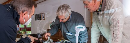 Drei Personen reparieren ein Elektrogerät im Repair Café. | © Die Bremer Stadtreinigung