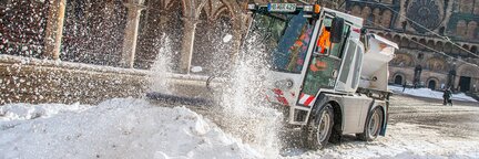 Auf dem Bremer Marktplatz fährt ein Räumungsfahrzeug des Winterdients durch einen Schneehaufen und macht die Straße wieder frei. | © Die Bremer Stadtreinigung