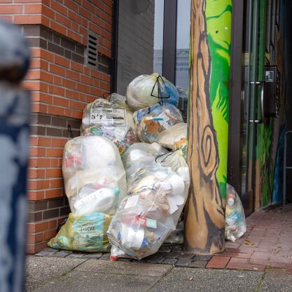 Mehrere gefüllte gelbe Säcke vor einem Hauseingang. | © Die Bremer Stadtreinigung Mehrere gelbe Säcke, in denen Verkaufsverpackungen enthalten sind. Die Säcke sind gestapelt vor einem Hauseingang. | © Die Bremer Stadtreinigung