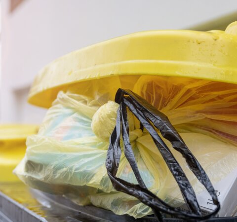 Der obere Teil einer gelben Tonne. Die Tonne ist leicht geöffnet. Ein gelber Sack mit Abfall ist zu sehen. | © Die Bremer Stadtreinigung Der obere Teil einer gelben Tonne. Der gelbe Deckel der Tonne ist leicht geöffnet, ein gelber Sack mit Abfall darin schaut heraus. | © Die Bremer Stadtreinigung