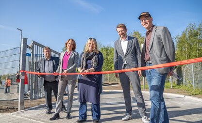 DBS eröffnet gemeinsam mit Maike Schaefer die Modern-Station in Burglesum. Maike Schaefer schneidet gerade das Band am Eingang durch. | © Die Bremer Stadtreinigung