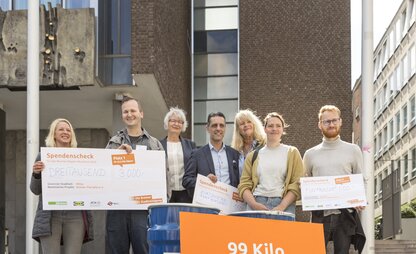 Ein Gruppenbild zeigt die Gewinner*innen des Kippen-Marathons 2022. Ein Schild zeigt, dass insgesamt 99 Kilo Zigarettenkippen gesammelt wurden. | © Die Bremer Stadtreinigung