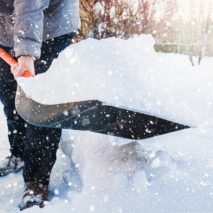 Eine Person schippt Schnee vor dem eigenen Grundstück. Das Bild stellt die private Anliegerpflicht im Winter dar. | © Die Bremer Stadtreinigung