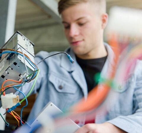 Junger Mann der kleine Elektrogeräte entsorgt. | © Die Bremer Stadtreinigung Ein Junger Mann der kleine Elektrogeräte in einer großen Tonne entsorgt. | © Die Bremer Stadtreinigung
