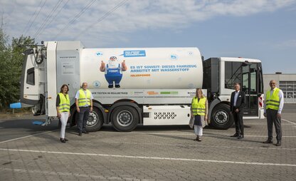 Daniela Enslein, Volker Ernst, Maike Schaefer und zwei weitere Mitarbeitende von DBS stehen vor einem wasserstoffbetriebenen Fahrzeug. | © Die Bremer Stadtreinigung