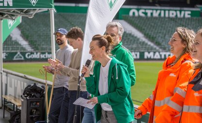 Anne-Kathrin Laufmann, Geschäftsführerin Sport & Nachhaltigkeit beim SV Werder Bremen, motiviert die Sammelnden