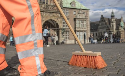 Ein Mitarbeiter von DBS reinigt die Straße am Marktplatz in Bremen mit einem Besen. | © Die Bremer Stadtreinigung