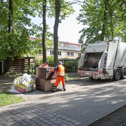 Müllfahrzeug mit zwei Mitarbeitenden von Die Bremer Stadtreinigung, die Sperrmüll abholen. | © Die Bremer Stadtreinigung Zwei Mitarbeitende von Die Bremer Stadtreinigung, die Sperrmüll in ein Müllfahrzeug laden. | © Die Bremer Stadtreinigung